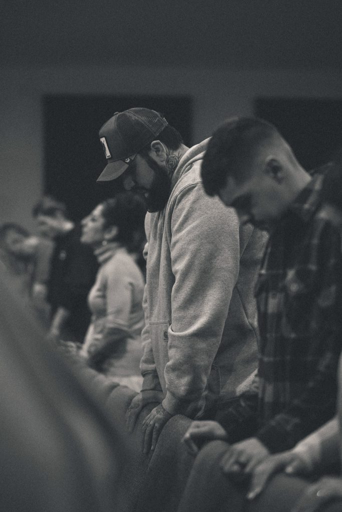 Man leaning on chair in powerful prayer moment at Church of the Valley in Chicopee, Pioneer Valley MA