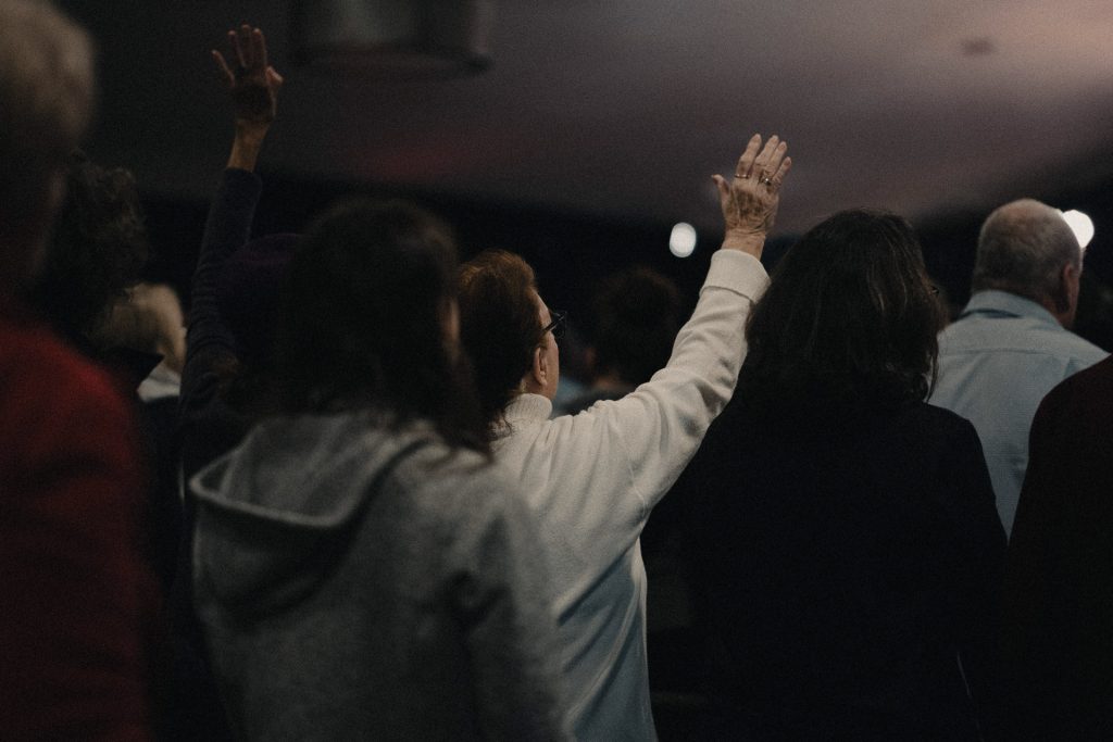 Woman raising hand in worship at Church of the Valley in Chicopee, Pioneer Valley MA