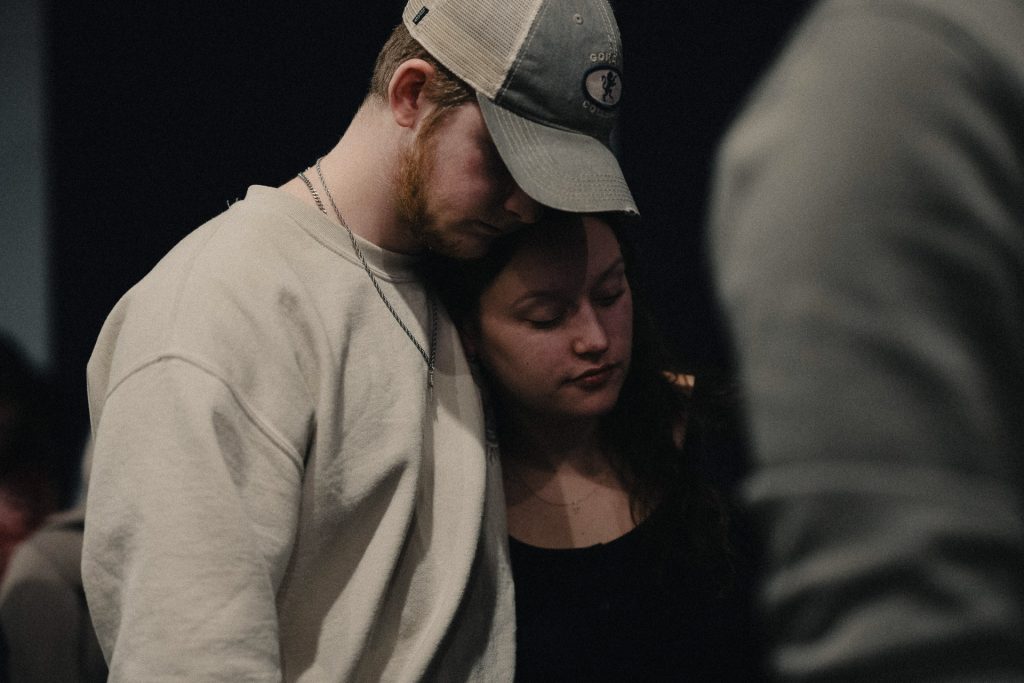 A couple hugging and praying Women Laughing in the foyer at Church of the Valley in Chicopee, Pioneer Valley MA.