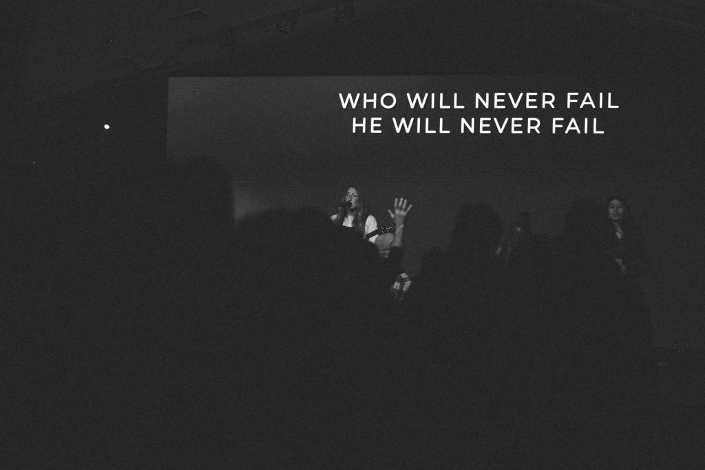 Man with hand raised in worship at Church of the Valley in Chicopee, Pioneer Valley MA